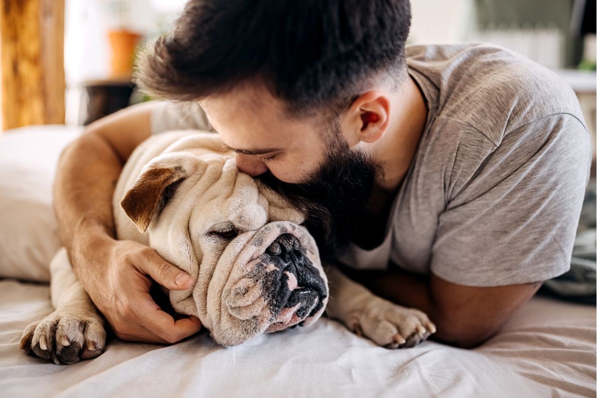 Man cuddling his bulldog